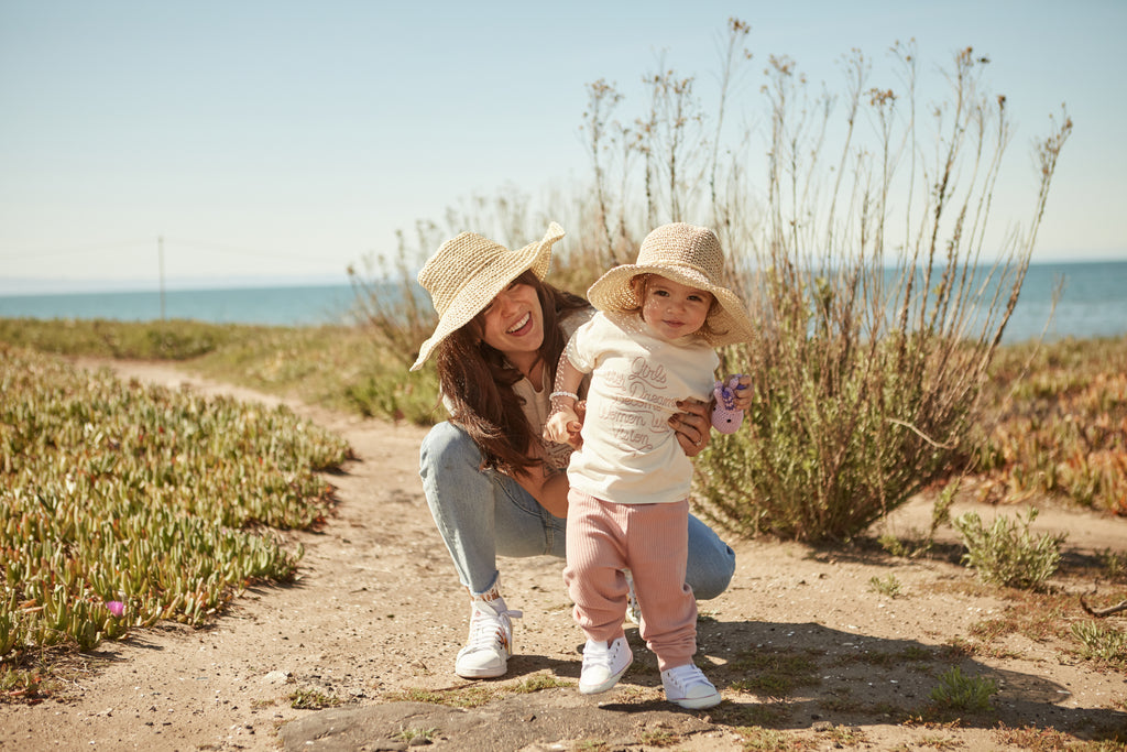 Mommy and Baby Daughter Wearing Matching Sun Hats By the Beach